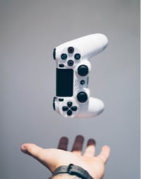 A person tosses a white video game controller, ready to conquer virtual worlds